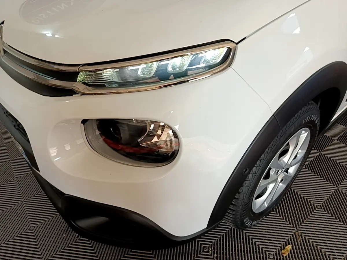 Gros plan sur l'avant droit blanc d'une Citroën C3 2019, mettant en valeur ses phares LED et la roue en jante alliage.