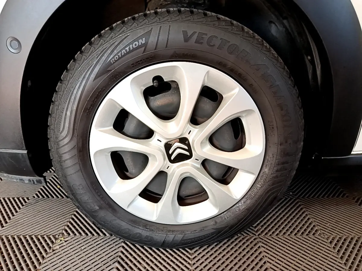 Gros plan sur la roue avant droite de la Citroën C3 blanche, mettant en valeur la jante acier et le pneu Goodyear.