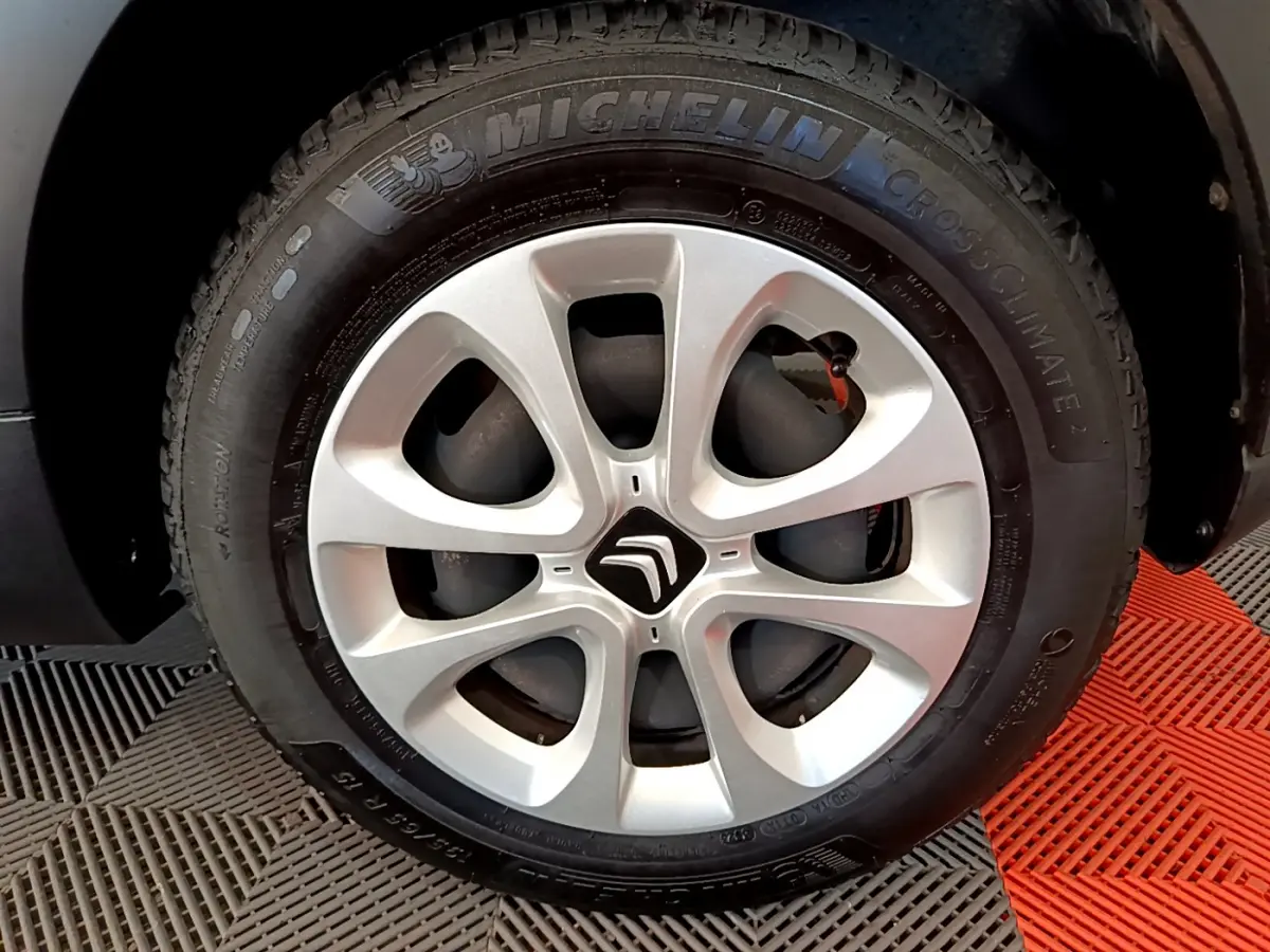 Gros plan sur la roue avant gauche d'une Citroën C3 blanche avec jante alliage et pneu Michelin CrossClimate.