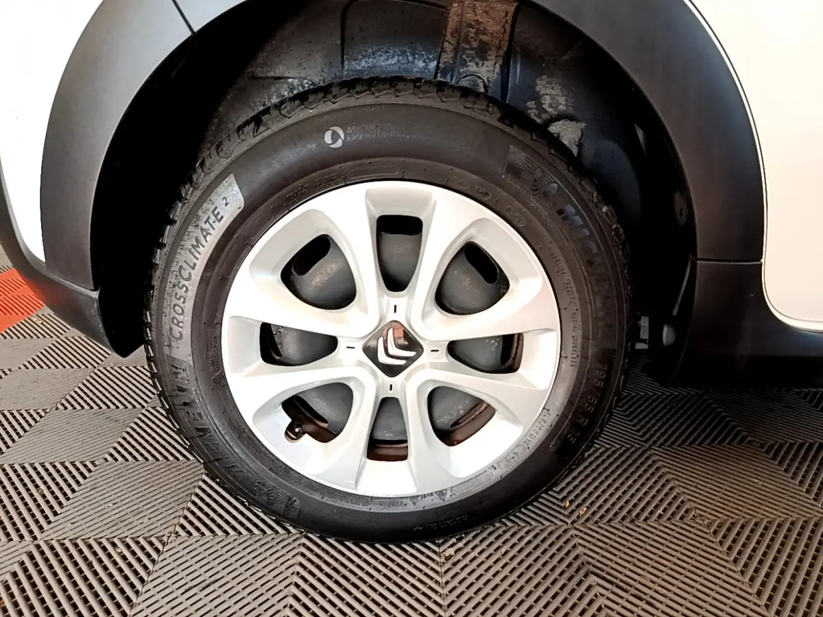 Gros plan sur la roue avant gauche blanche d'une Citroën C3 2019, avec jante alliage et pneu Michelin.