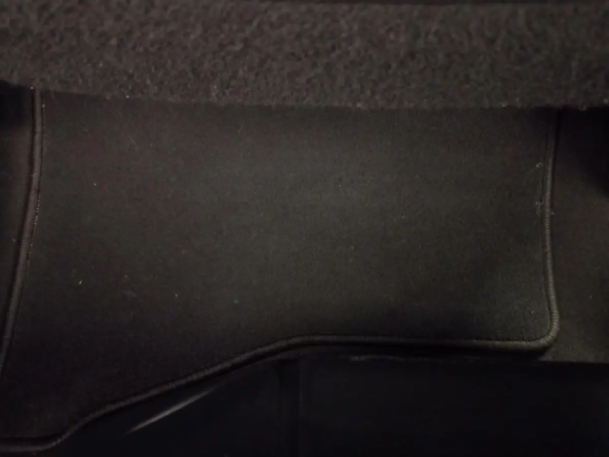 Tapis de sol noir intérieur de Toyota Yaris 1.5 VVT-I HYBRID France Business, vue rapprochée du plancher passager.