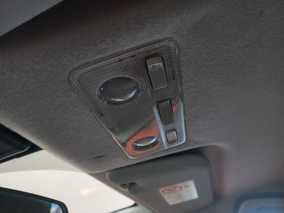 Plafonnier intérieur gris avec commandes d'éclairage, vu de près dans une Toyota Yaris noire hybride 2018.