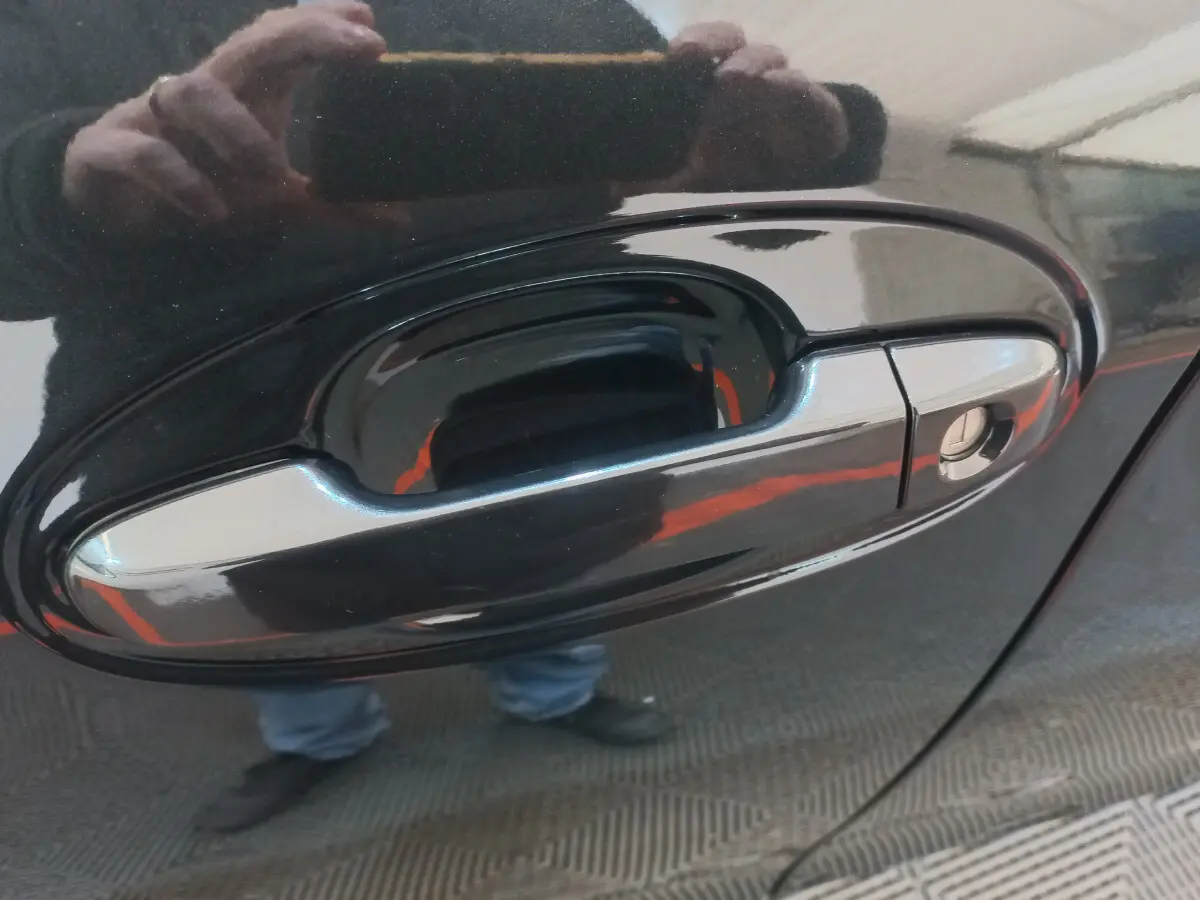 Poignée de porte côté droit noir brillant de la Toyota Yaris 1.5 VVT-I Hybrid France Business 2018 avec serrure visible.