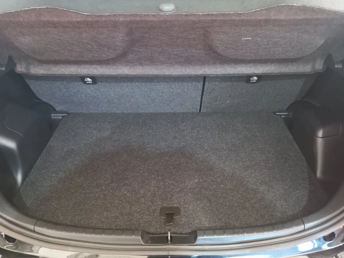 Coffre ouvert vu de face d'une Toyota Yaris noire, montrant un espace de chargement propre et spacieux.