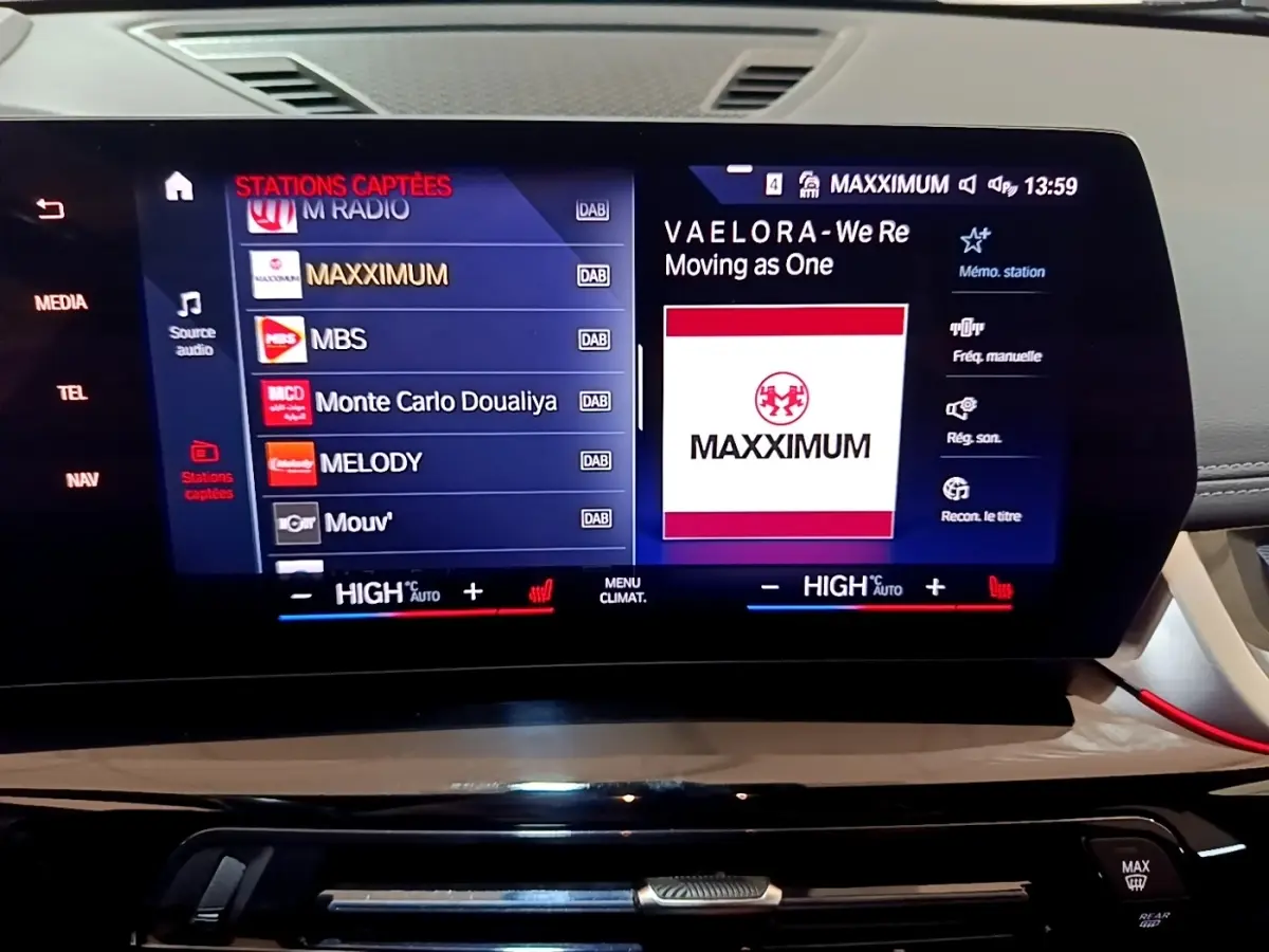 Écran tactile central du BMW X1 xDrive23i M Sport 2023 affichant la radio et commandes climatisation.