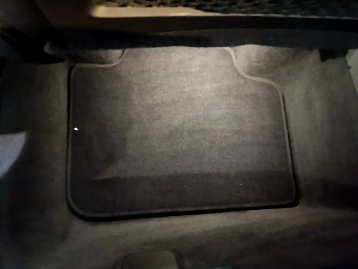 Tapis de sol noir vu de dessus à l'intérieur d'un BMW X1 xDrive23i M Sport gris clair, 2023.