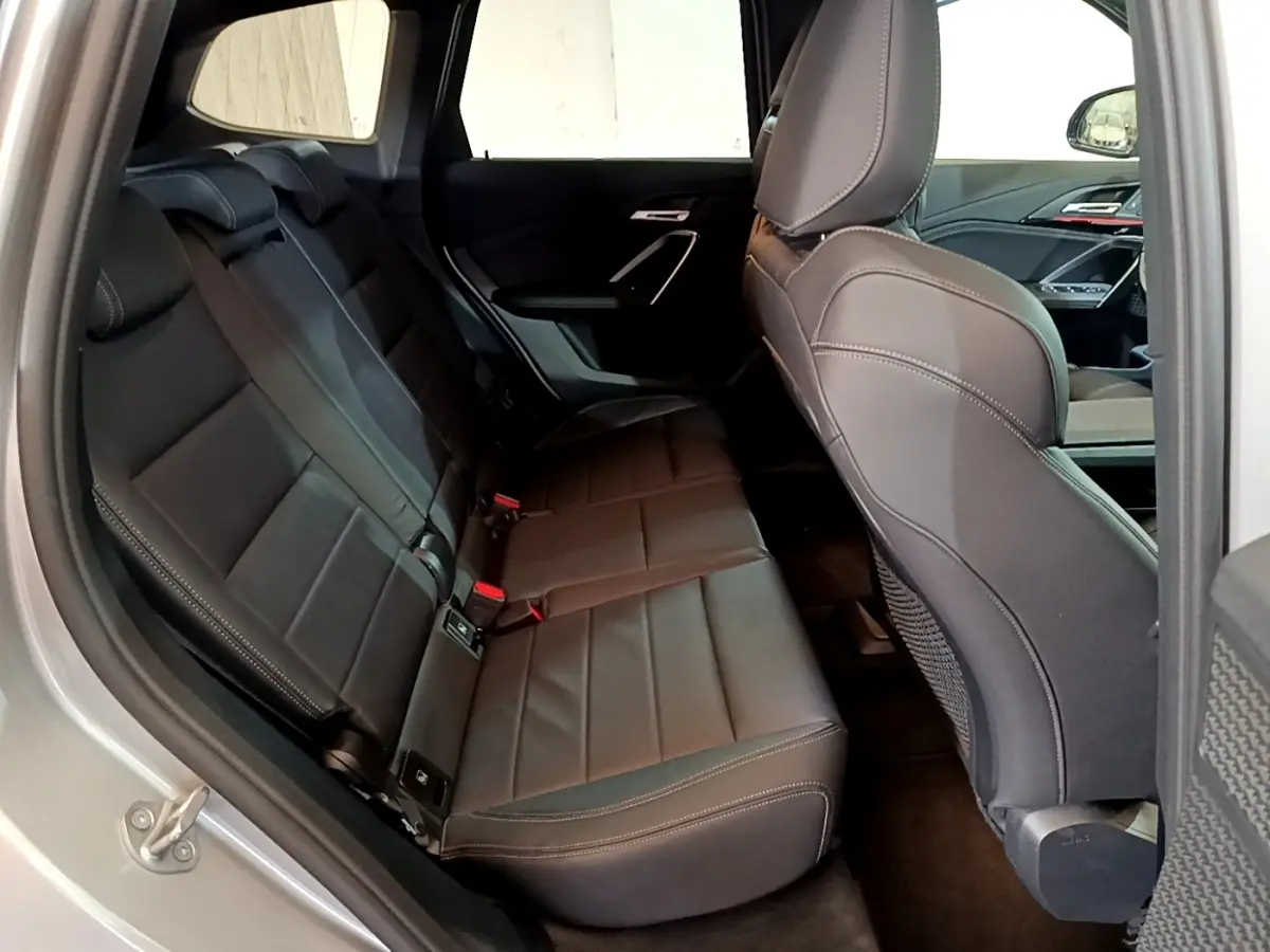 Vue intérieure côté gauche montrant les sièges arrière en cuir noir du BMW X1 xDrive23i M Sport gris clair 2023.