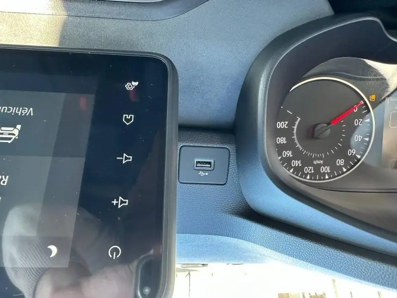 Vue rapprochée du tableau de bord du Dacia Jogger blanc 2024, montrant l'écran tactile et le compteur de vitesse.