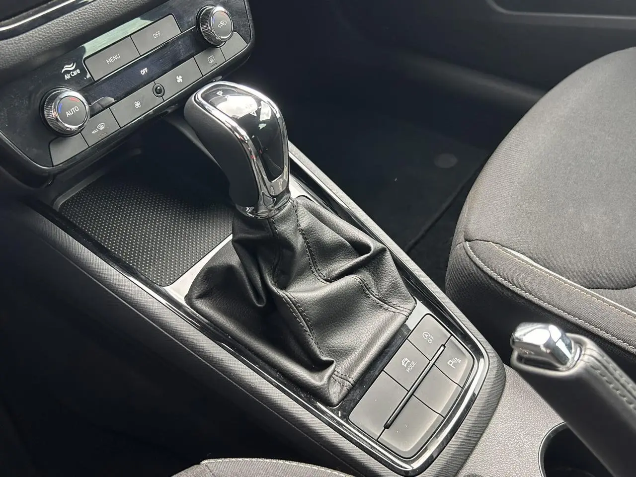 Gros plan sur la console centrale intérieure de la Skoda Scala 2025, avec levier de vitesse automatique et commandes noires.