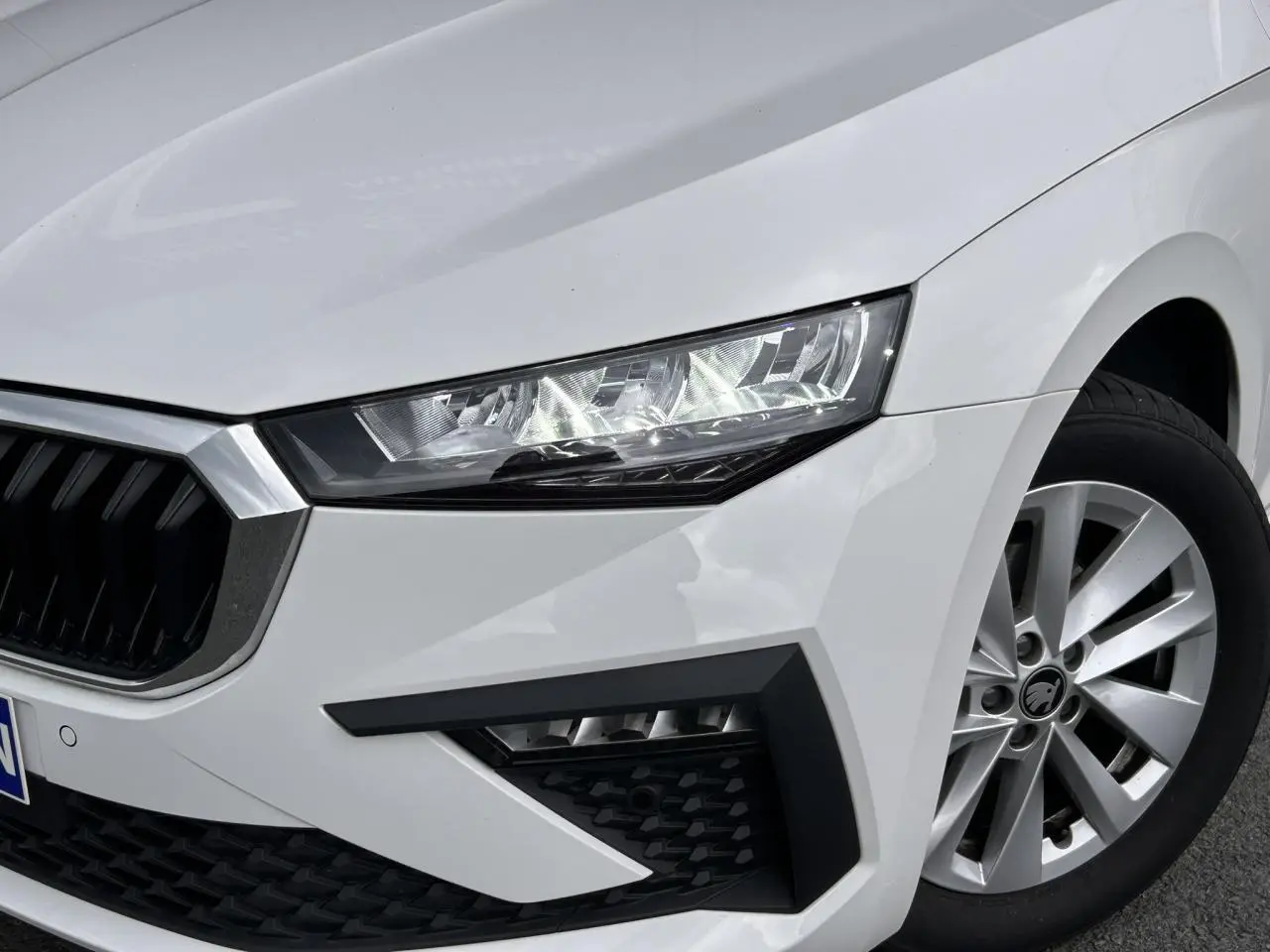 Gros plan sur l'avant droit blanc Candy de la Skoda Scala 2025 avec phares Full LED et jante alliage 16 pouces.