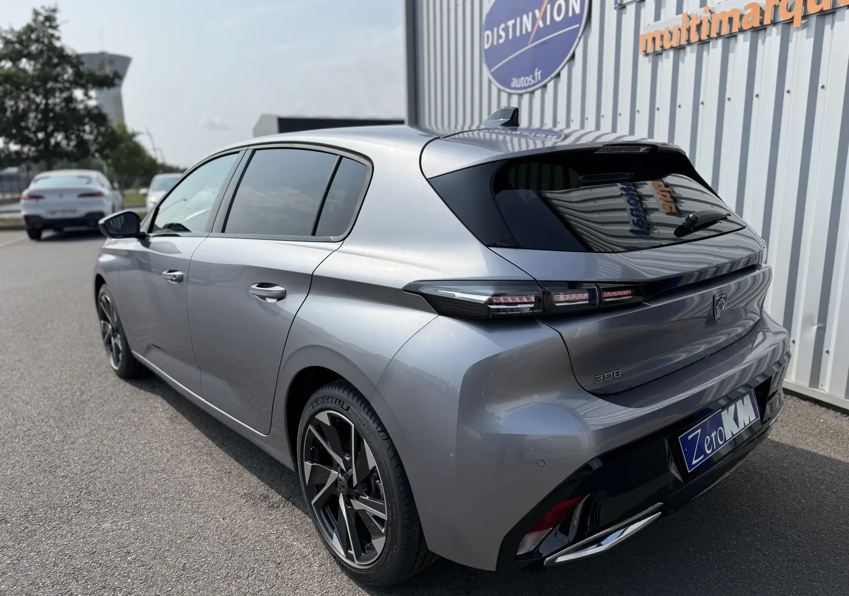 Peugeot 308 gris Artense vue 3/4 arrière droit, avec feux arrière LED et jantes alliage bicolores.