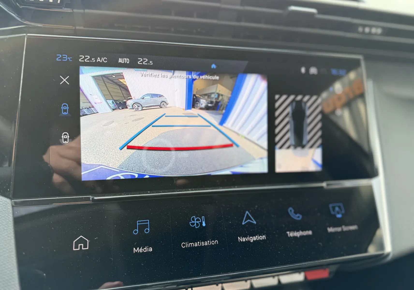 Écran tactile intérieur montrant la caméra de recul et l'affichage 360° du Peugeot 308 gris Artense de 2025.