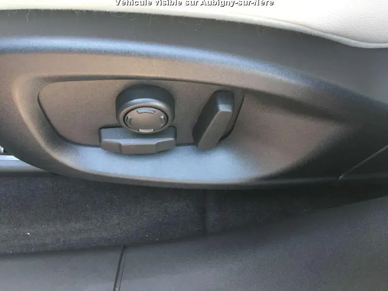 Gros plan sur les commandes de réglage électrique du siège avant d'une Jaguar F-PACE noire de 2018.