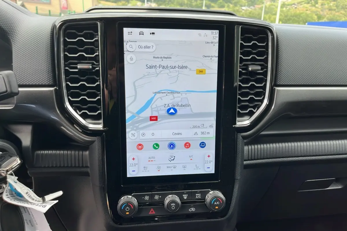 Écran tactile central du Ford Ranger 2025 gris carbone, affichant la navigation avec commandes climatisation en dessous.