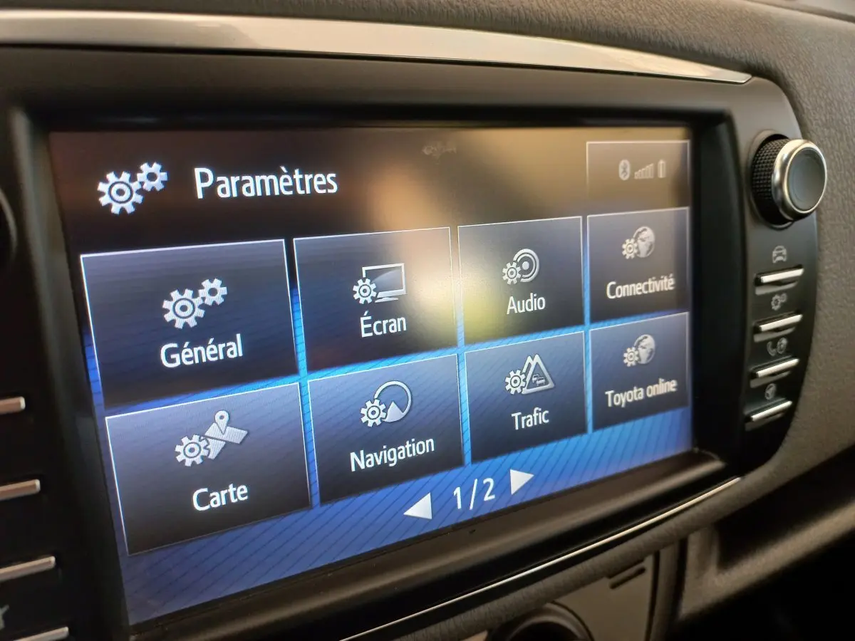 Écran tactile central de la Toyota Yaris hybride 2019 affichant le menu paramètres en intérieur noir.