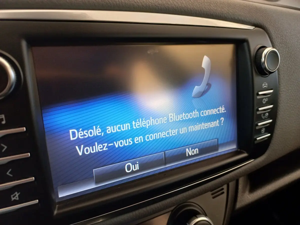 Écran tactile central de la Toyota Yaris 2019 affichant un message Bluetooth, vue rapprochée de l'intérieur noir.