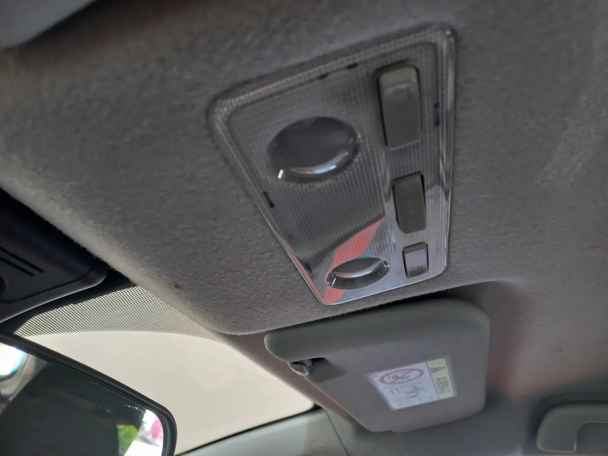 Plafonnier intérieur et pare-soleil côté conducteur de la Toyota Yaris blanche, version hybride 2019.
