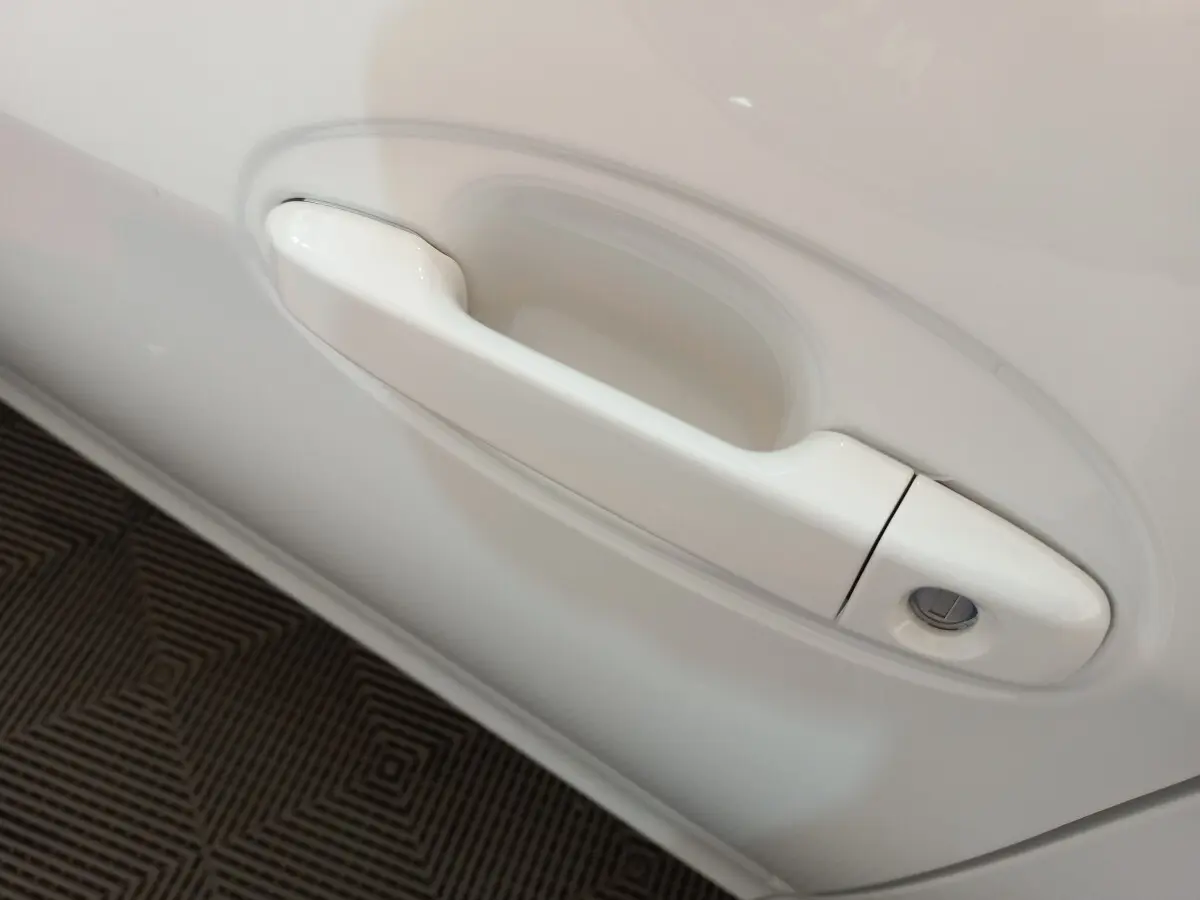 Poignée de porte blanche côté gauche de la Toyota Yaris 1.5 VVT-I HYBRID France Business 2019 vue en gros plan.