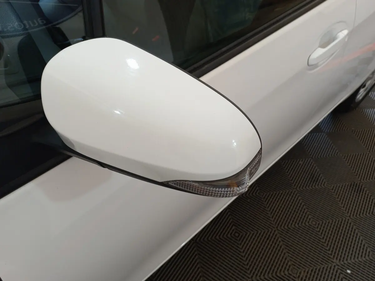 Rétroviseur côté gauche blanc de la Toyota Yaris hybride 2019, avec clignotant intégré, vue rapprochée sur porte.