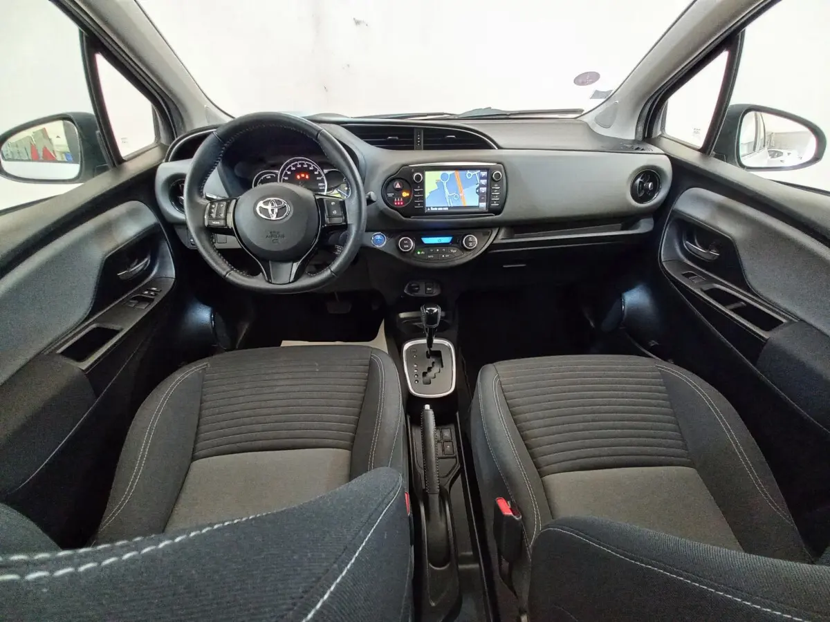 Vue intérieure avant de la Toyota Yaris hybride 2019, montrant le tableau de bord avec écran tactile et volant multifonctions.