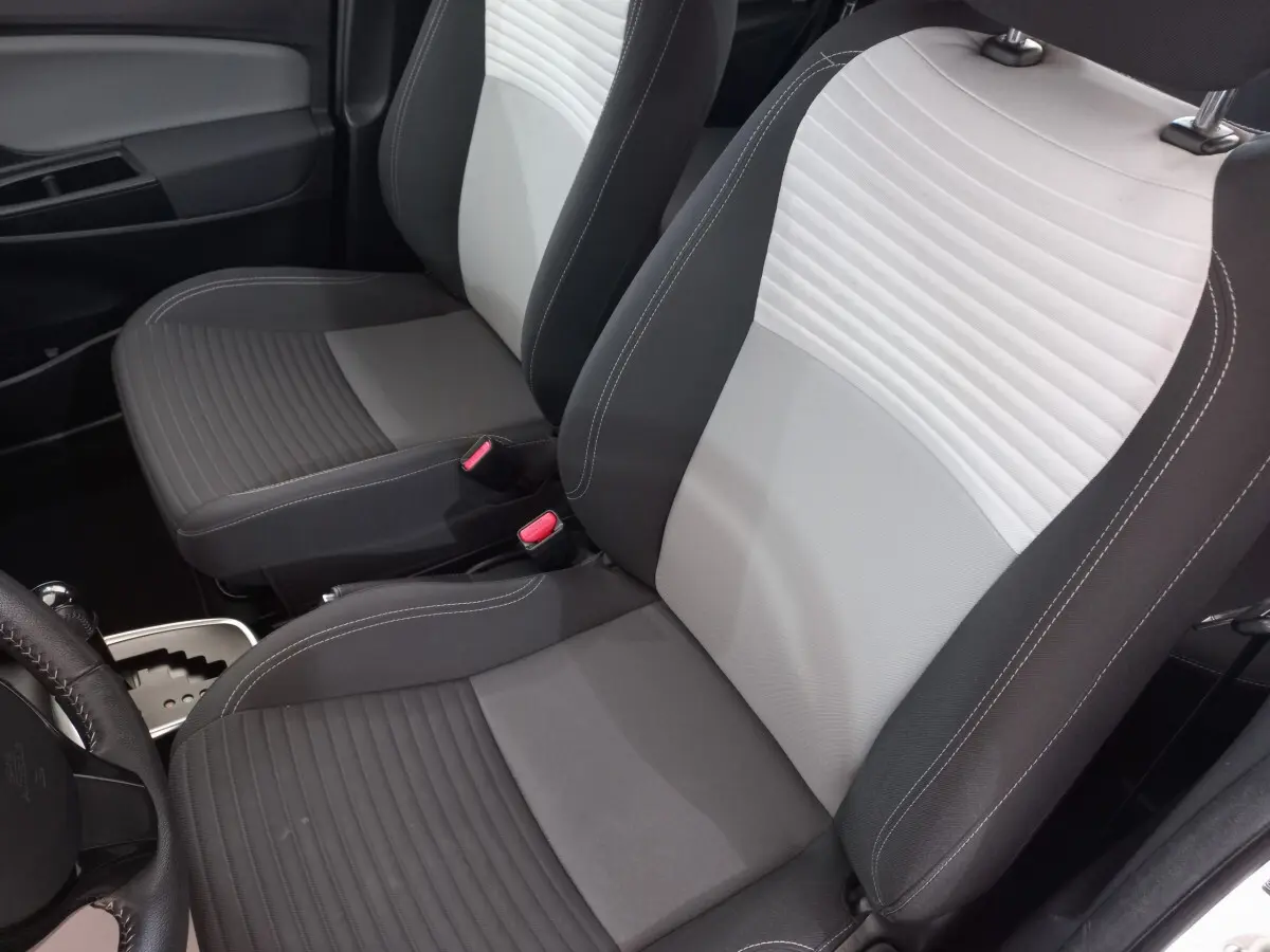 Gros plan sur les sièges avant gris clair et foncé de la Toyota Yaris 1.5 Hybrid, intérieur moderne et épuré.