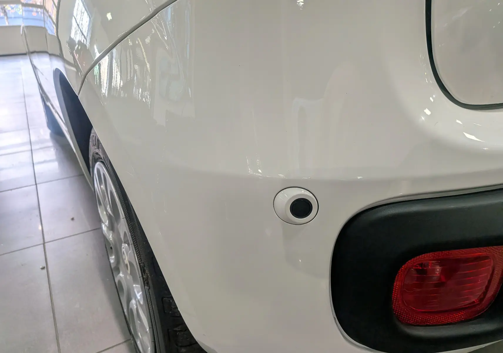 Gros plan sur l'arrière droit blanc gelato d'une Fiat Panda 1.0 Hybrid 2025 avec feu rouge et capteur de recul.