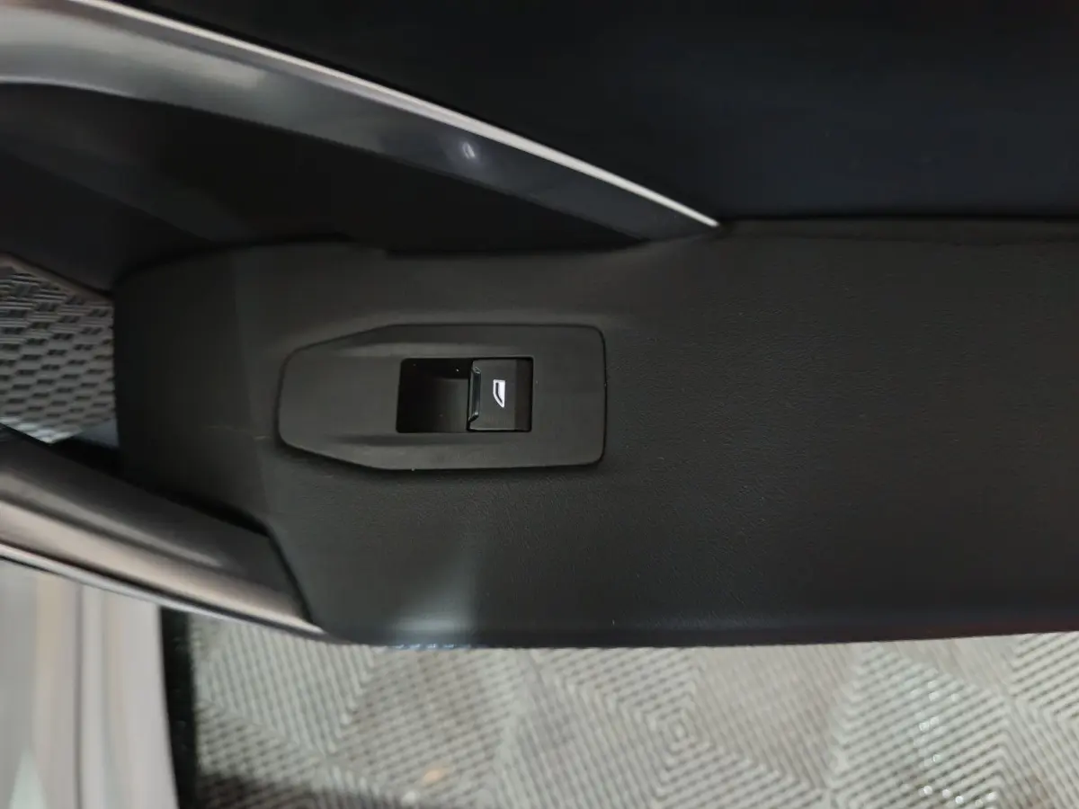 Bouton de commande de lève-vitre sur la portière intérieure côté gauche d’un BMW X1 blanc 2024.