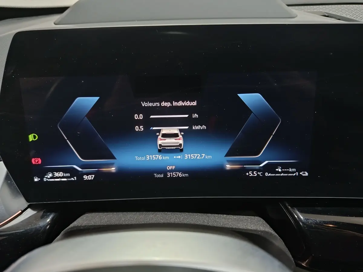 Affichage numérique du combiné d'instruments du BMW X1 blanc, version xDrive25e M Sport, vue frontale du tableau de bord.