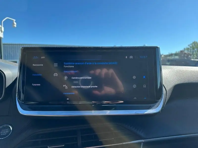 Tablette tactile du tableau de bord du Peugeot 2008 Hybrid 2025 affichant les aides à la conduite, vue de face en intérieur.