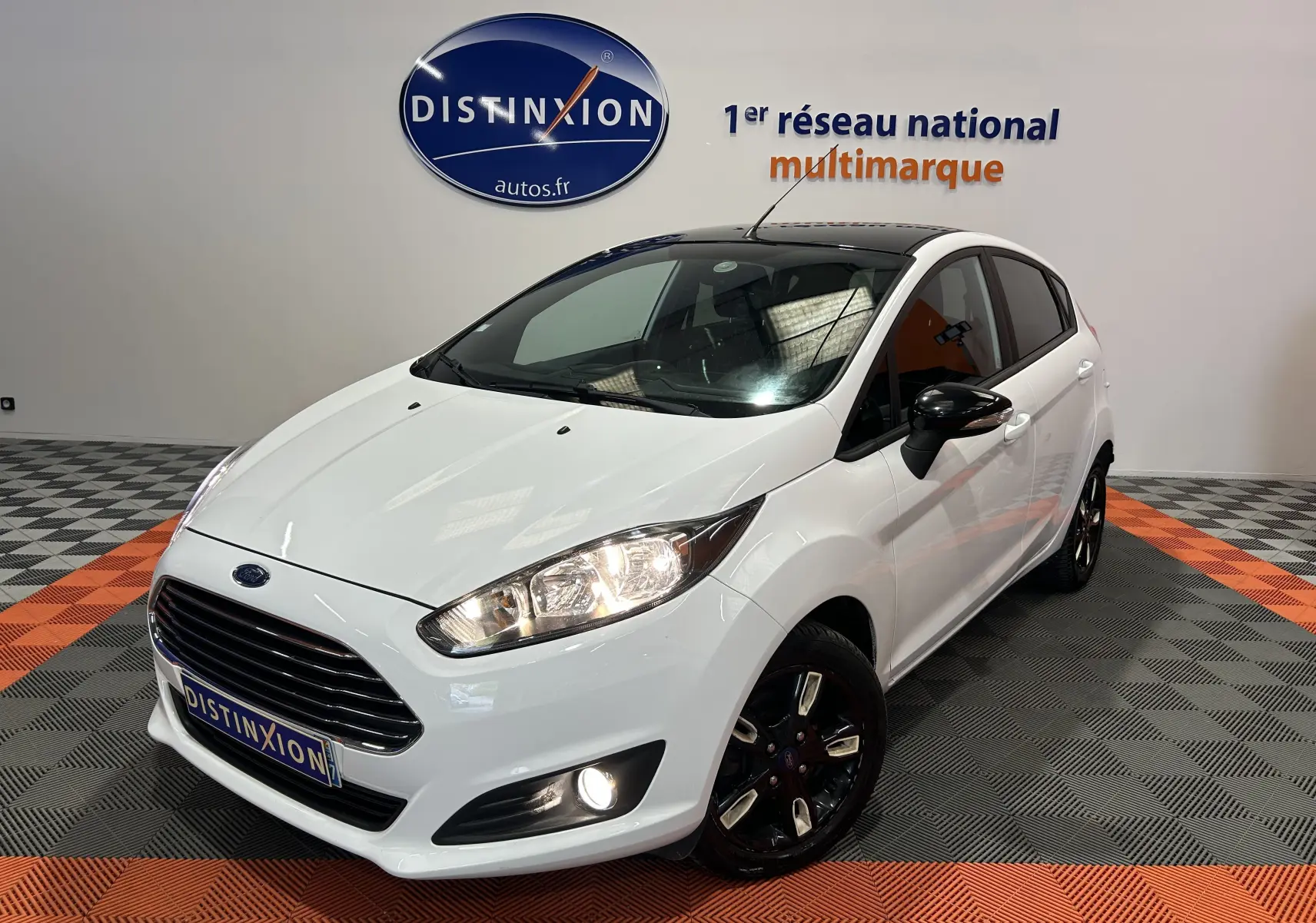 Ford Fiesta EcoBoost blanche vue en 3/4 avant droit, avec jantes noires et toit panoramique noir.