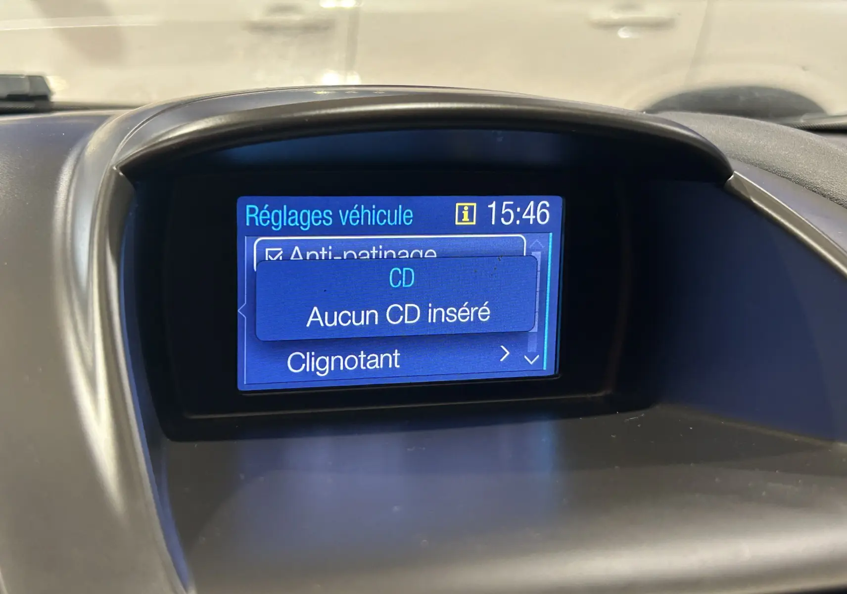 Écran central du tableau de bord de la Ford Fiesta blanc, affichant les réglages véhicule et l'heure 15:46.