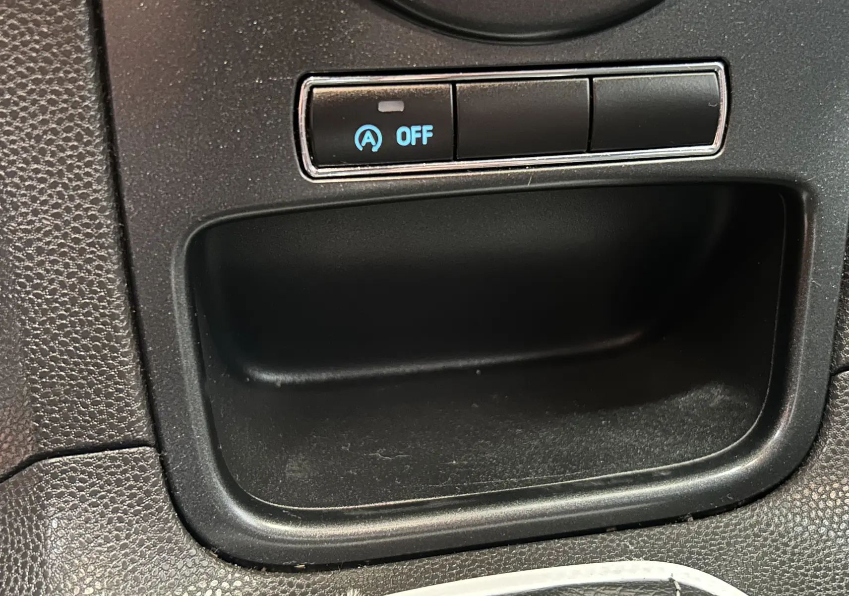 Gros plan sur le bouton Stop&Start désactivé dans l’habitacle noir de la Ford Fiesta EcoBoost blanche de 2015.