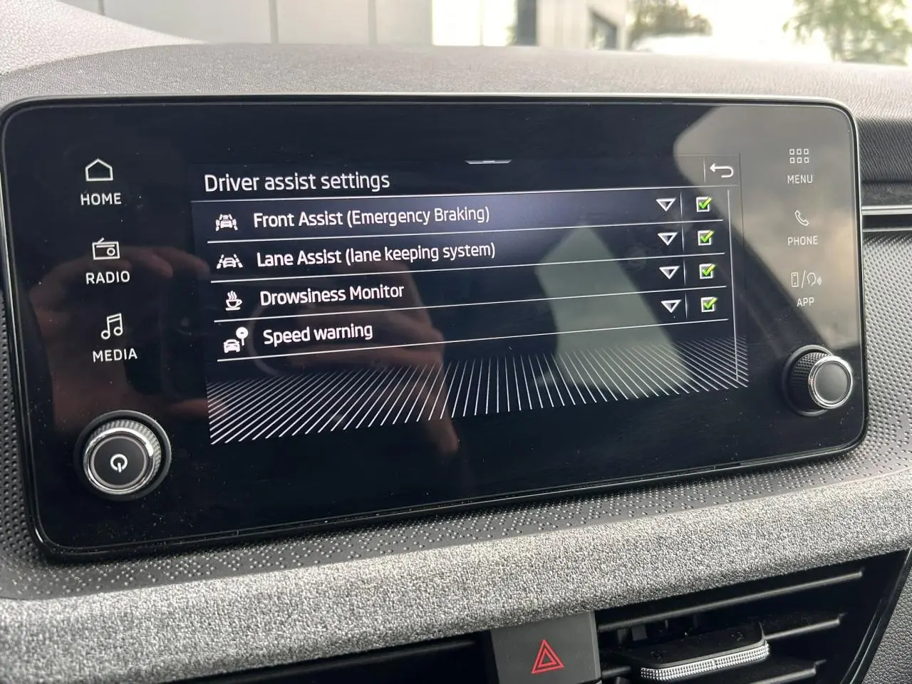 Écran tactile central affichant les réglages d'assistance à la conduite dans l'habitacle d'une Skoda Scala.