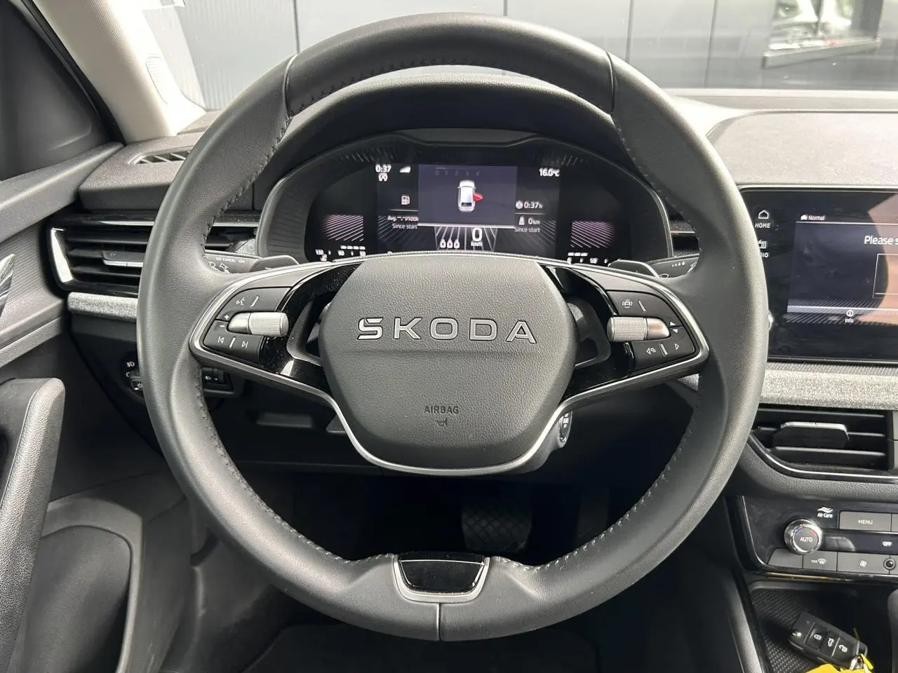 Vue frontale du volant cuir multifonctions SKODA SCALA 2025 avec tableau de bord digital et écran tactile à droite.
