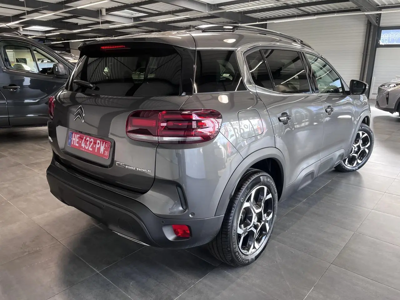 Vue 3/4 arrière droite d'un Citroën C5 Aircross gris platinium avec jantes alliage bi-ton et feux LED 3D.