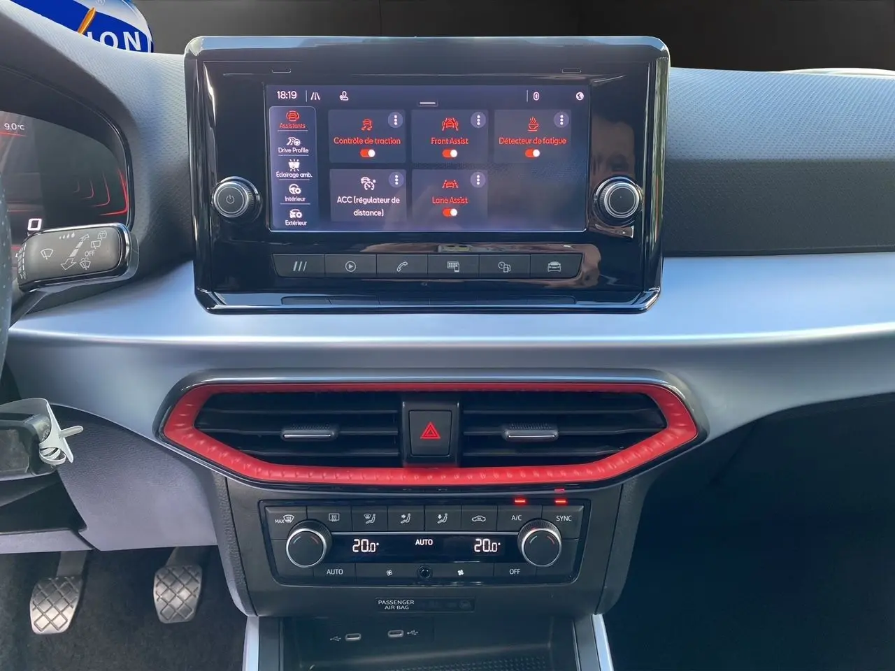 Tableau de bord du SEAT Arona 2024 avec écran tactile, climatisation bi-zone et cadre d’aération rouge vif.