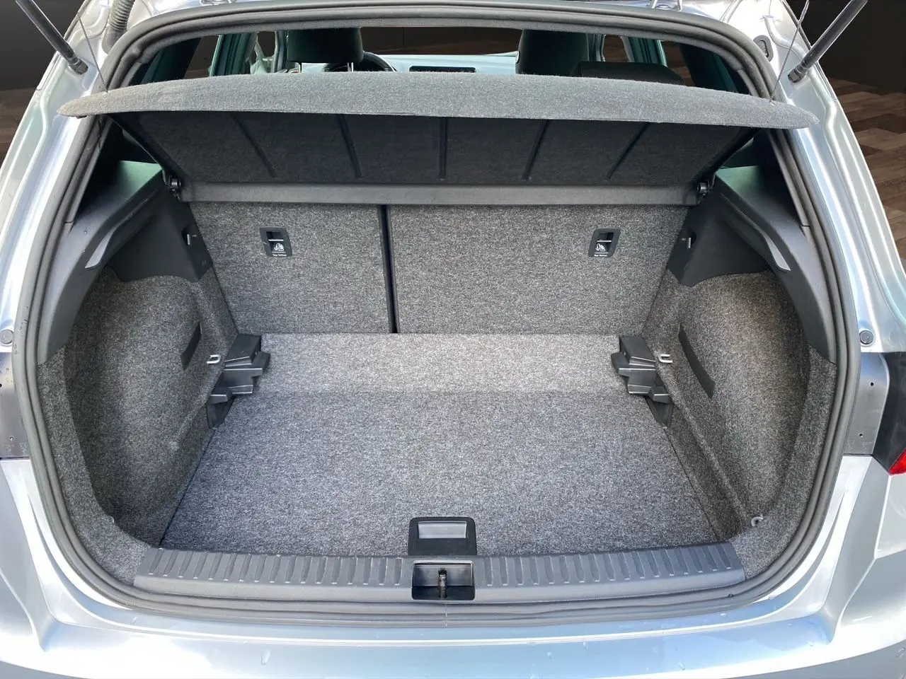 Coffre ouvert d'un SEAT Arona gris silver, vue arrière montrant l'espace de chargement et la moquette intérieure.