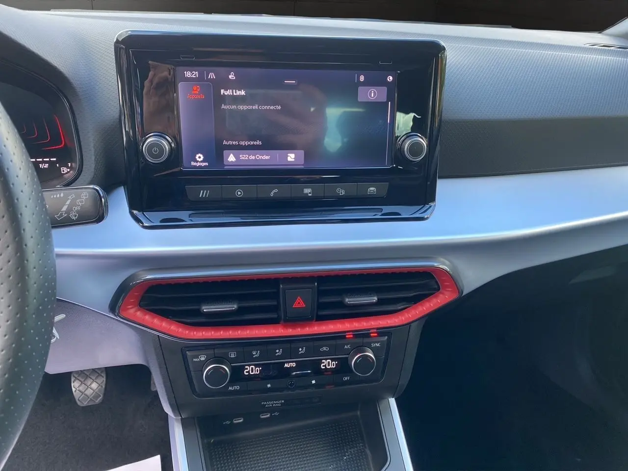 Vue rapprochée du tableau de bord gris et noir du SEAT Arona 2024, avec écran tactile et commandes de climatisation.