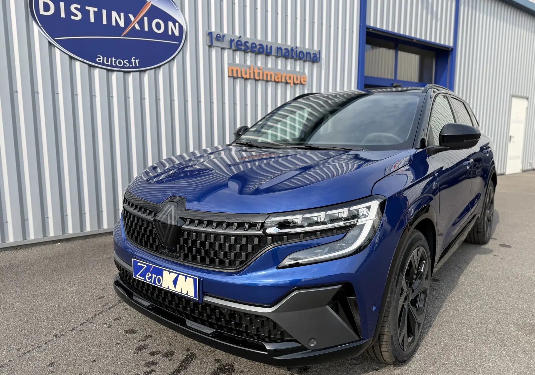 Renault Austral 2025 bleu Iron avec toit noir, vue 3/4 avant mettant en valeur sa calandre noire et ses phares LED.