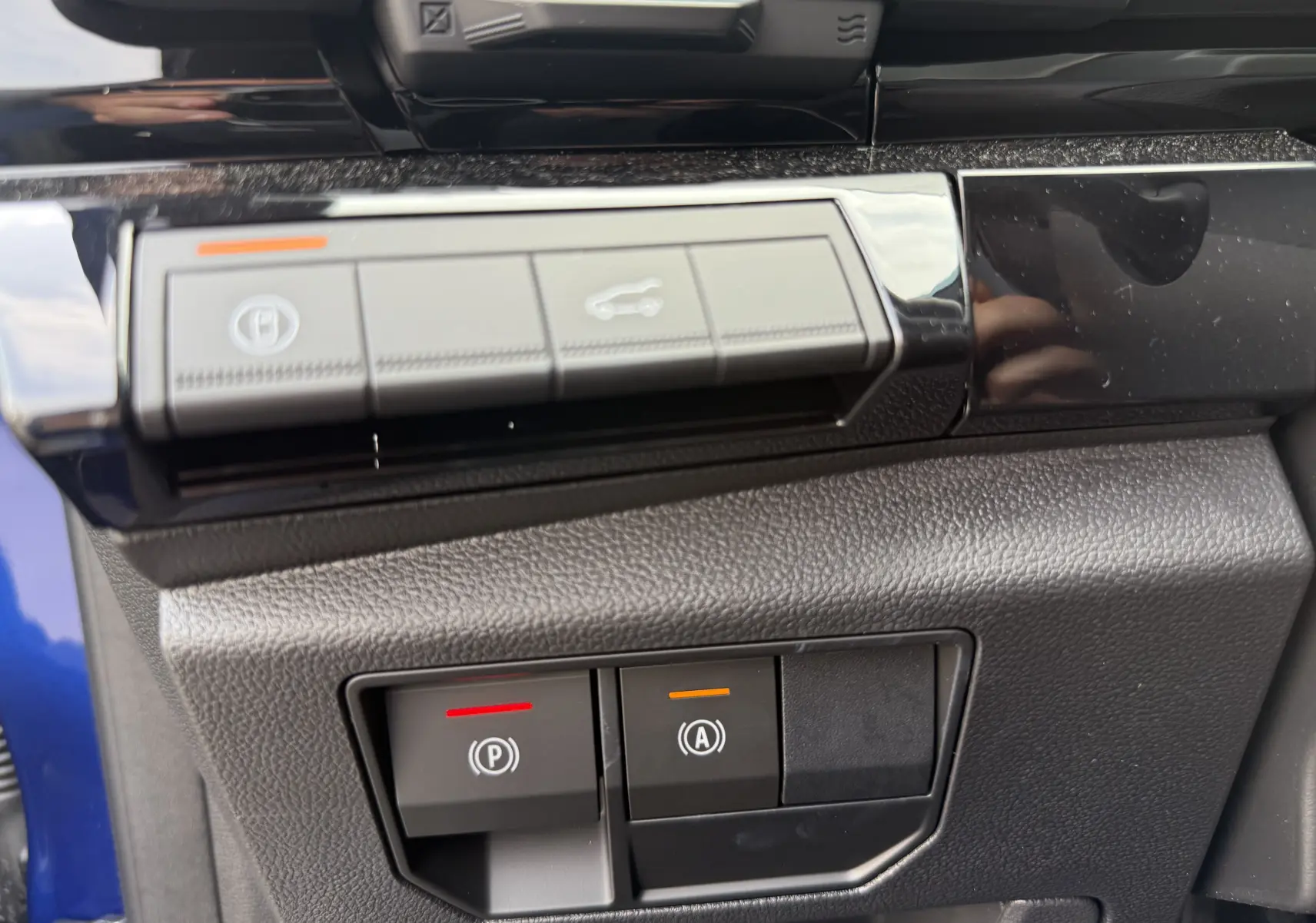 Gros plan sur les commandes de frein à main et assistance au démarrage du Renault Austral 2025 bleu Iron avec toit noir.