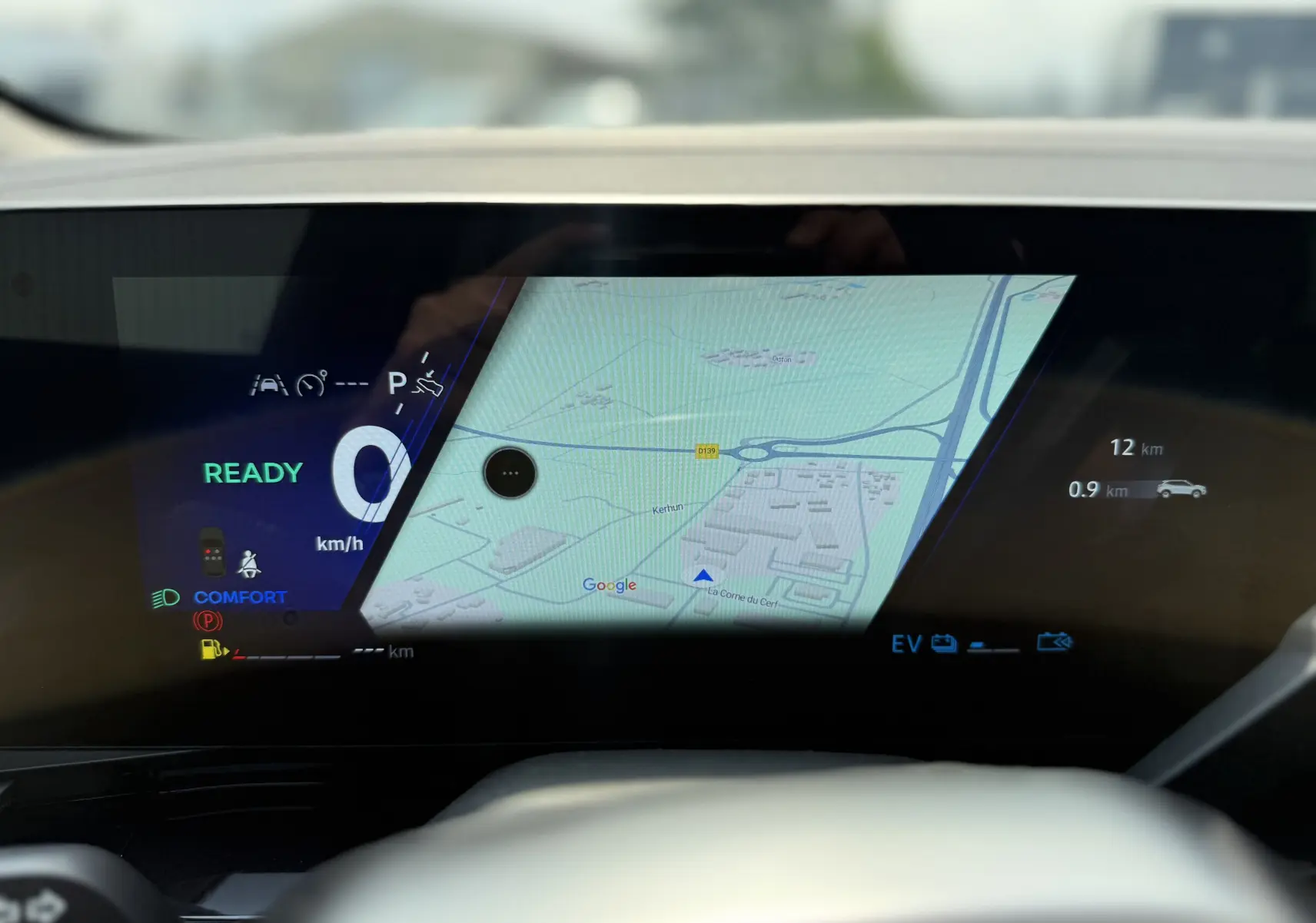 Tableau de bord numérique du Renault Austral 2025 avec affichage de la navigation et indicateurs de conduite en mode hybride.