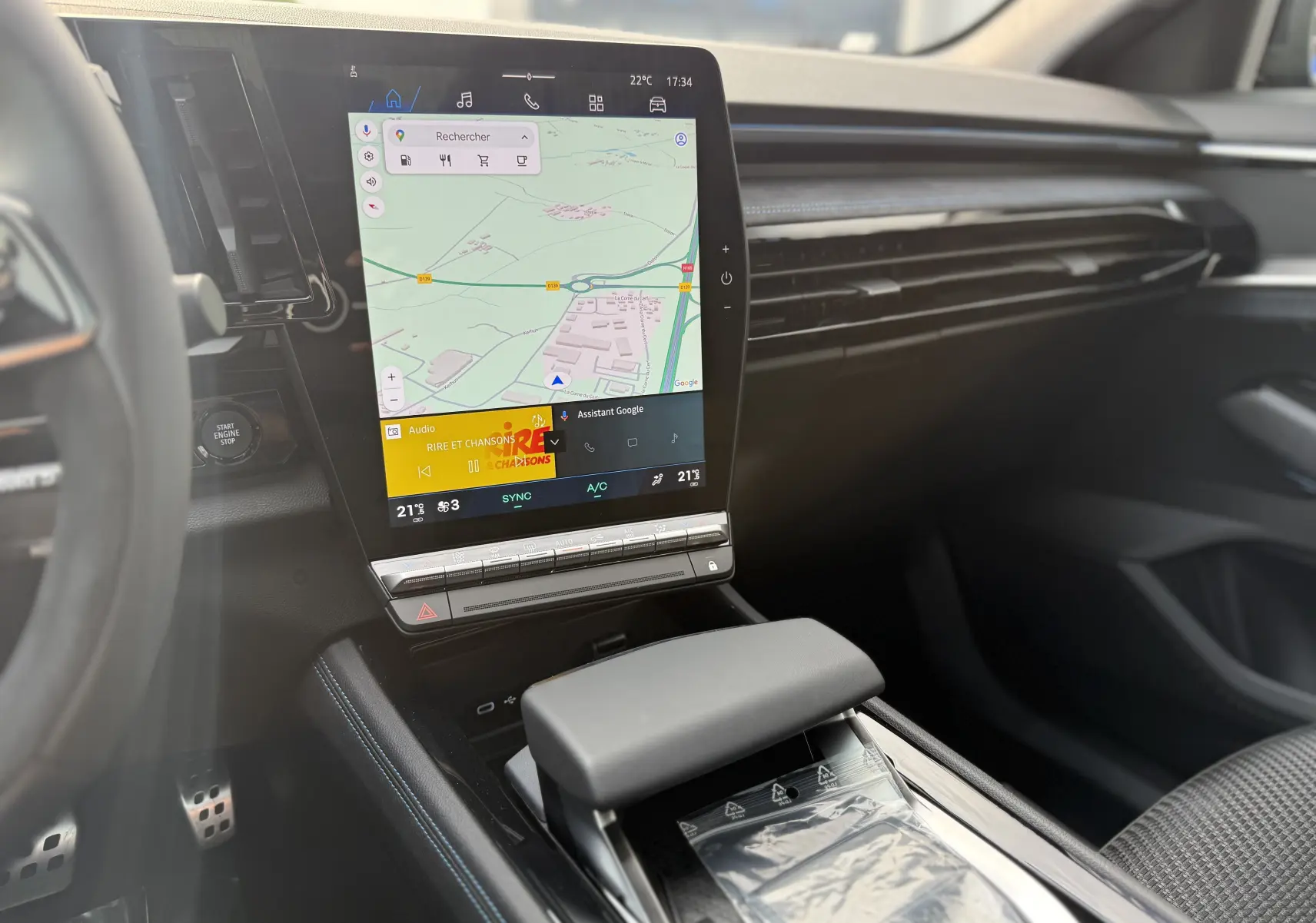 Intérieur du Renault Austral 2025 avec écran tactile vertical affichant la navigation, console centrale noire et volant partiel visible.