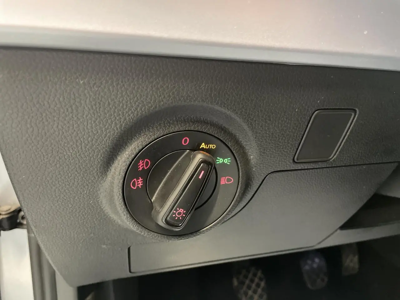 Gros plan sur le bouton de commande des phares du tableau de bord d'une SEAT Arona 2024 couleur GRS.