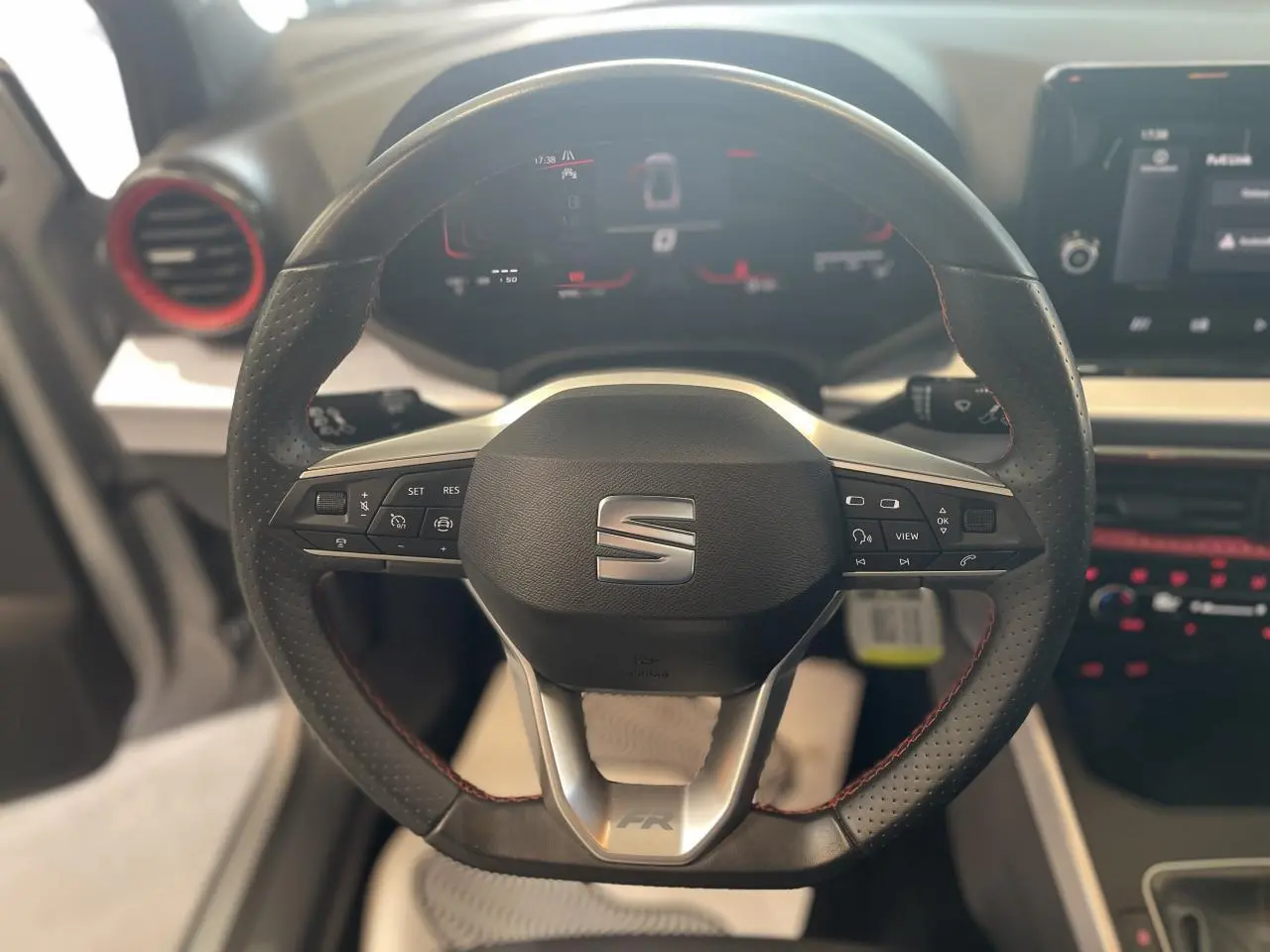 Volant sport cuir multifonction avec logo SEAT et insert FR, vue frontale du poste de conduite intérieur du SEAT Arona 2024.