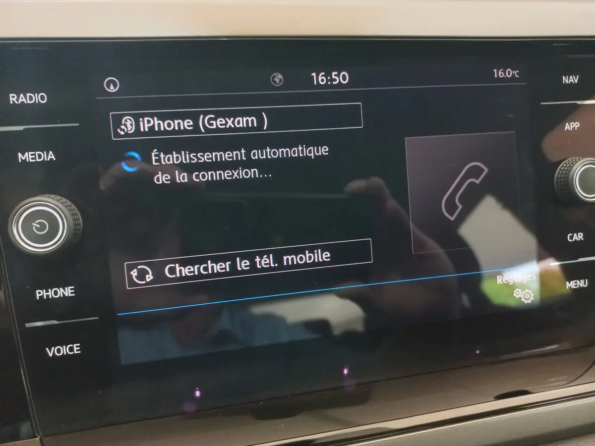 Écran tactile central de la Volkswagen Polo noire 2020 affichant la connexion Bluetooth d'un iPhone.