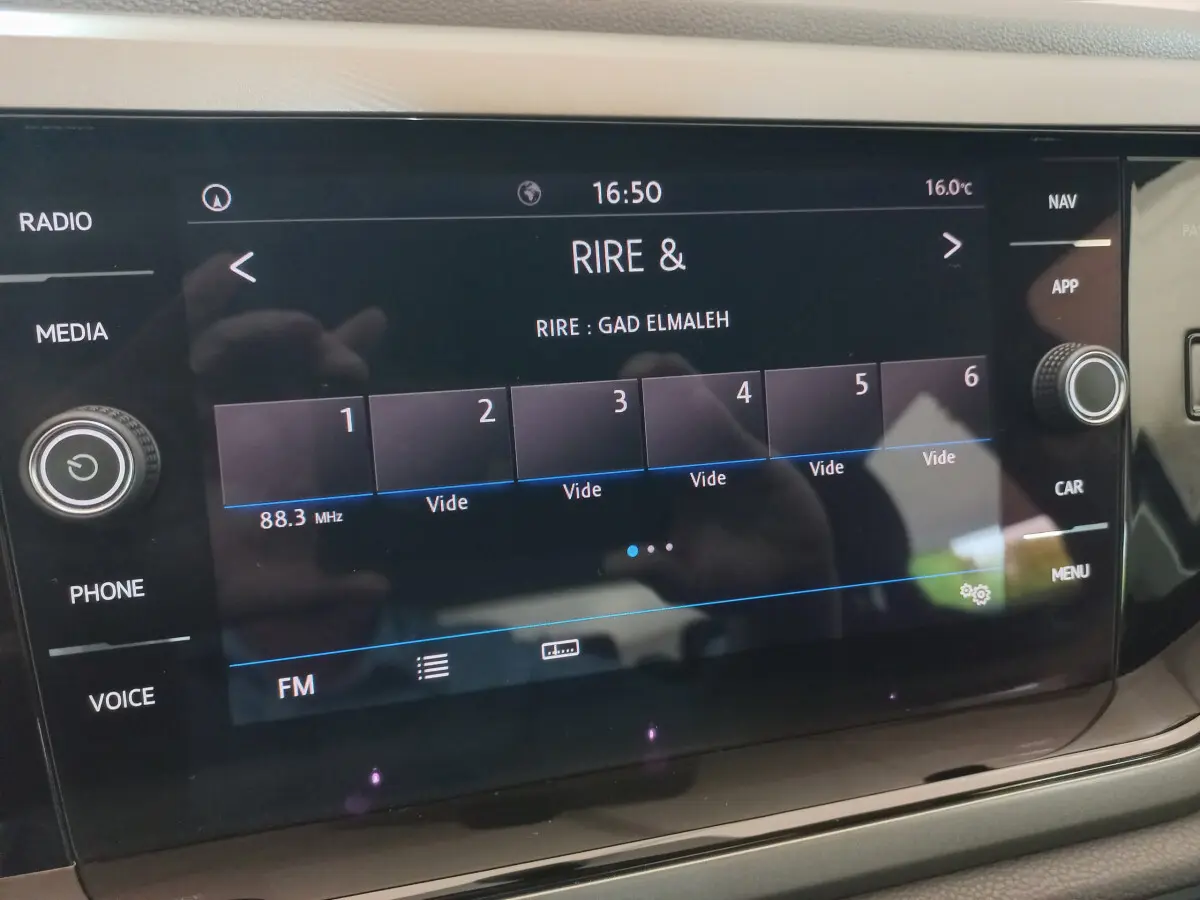 Écran tactile central noir de la Volkswagen Polo 2020 affichant une station radio FM à 16h50