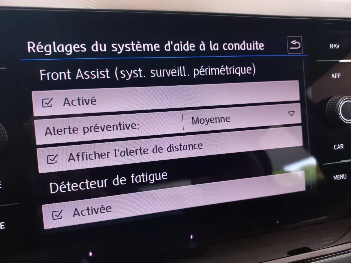 Écran tactile intérieur de la Volkswagen Polo noire montrant les réglages d'aide à la conduite et détecteur de fatigue activés.