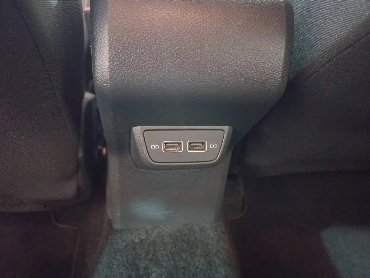 Prise double USB pour recharge située à l'arrière de la console centrale dans l'habitacle noir d'une Volkswagen Polo 2020.