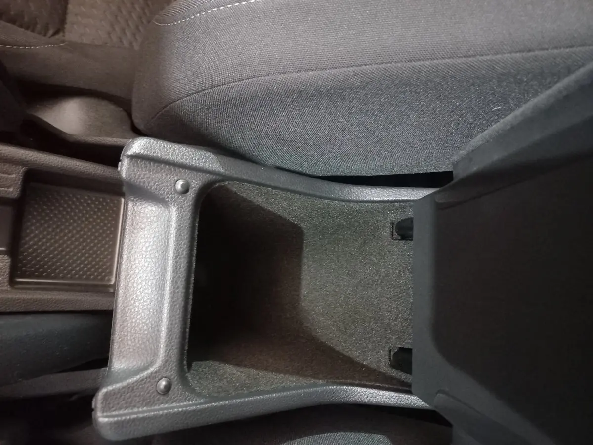 Vue rapprochée de la console centrale noire ouverte entre les sièges avant d'une Volkswagen Polo 2020.