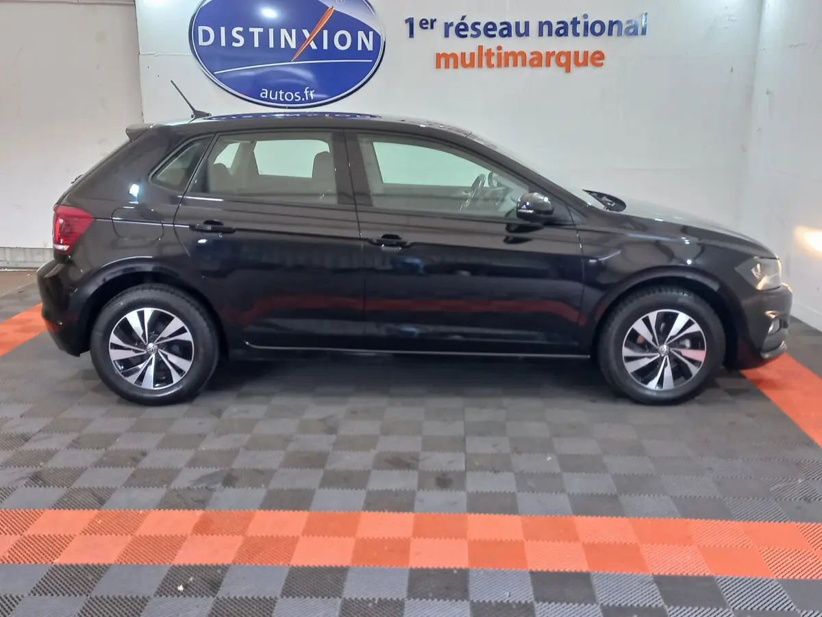 Profil côté gauche d'une Volkswagen Polo noire 2020 dans un showroom avec jantes alliage et vitres teintées.